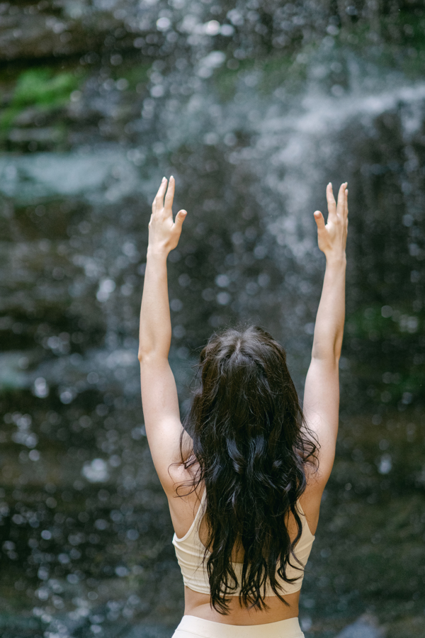 Yoga practice in front of a waterfall with Sanctus Heal